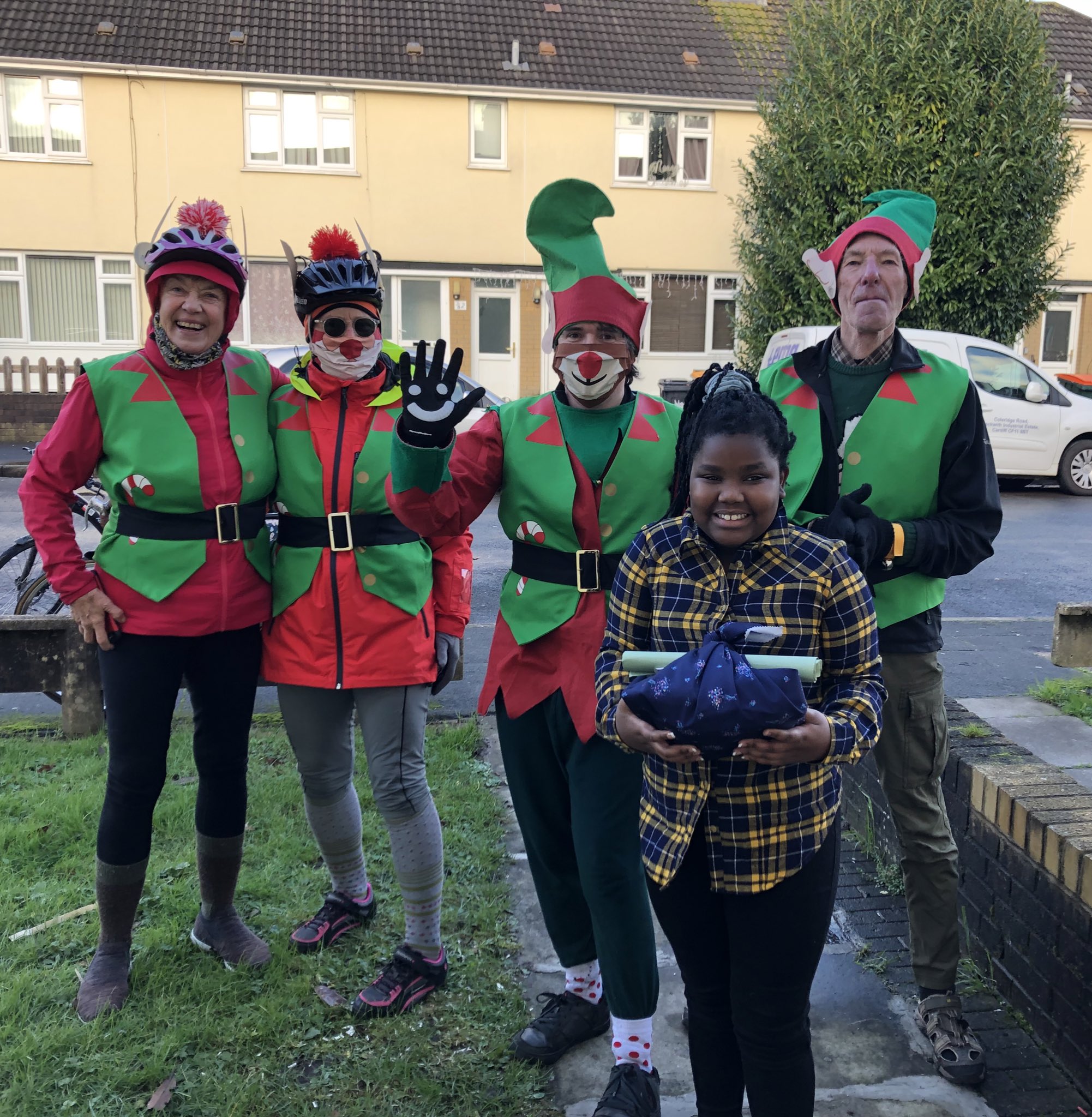 Elves dropping off presents to a young girl