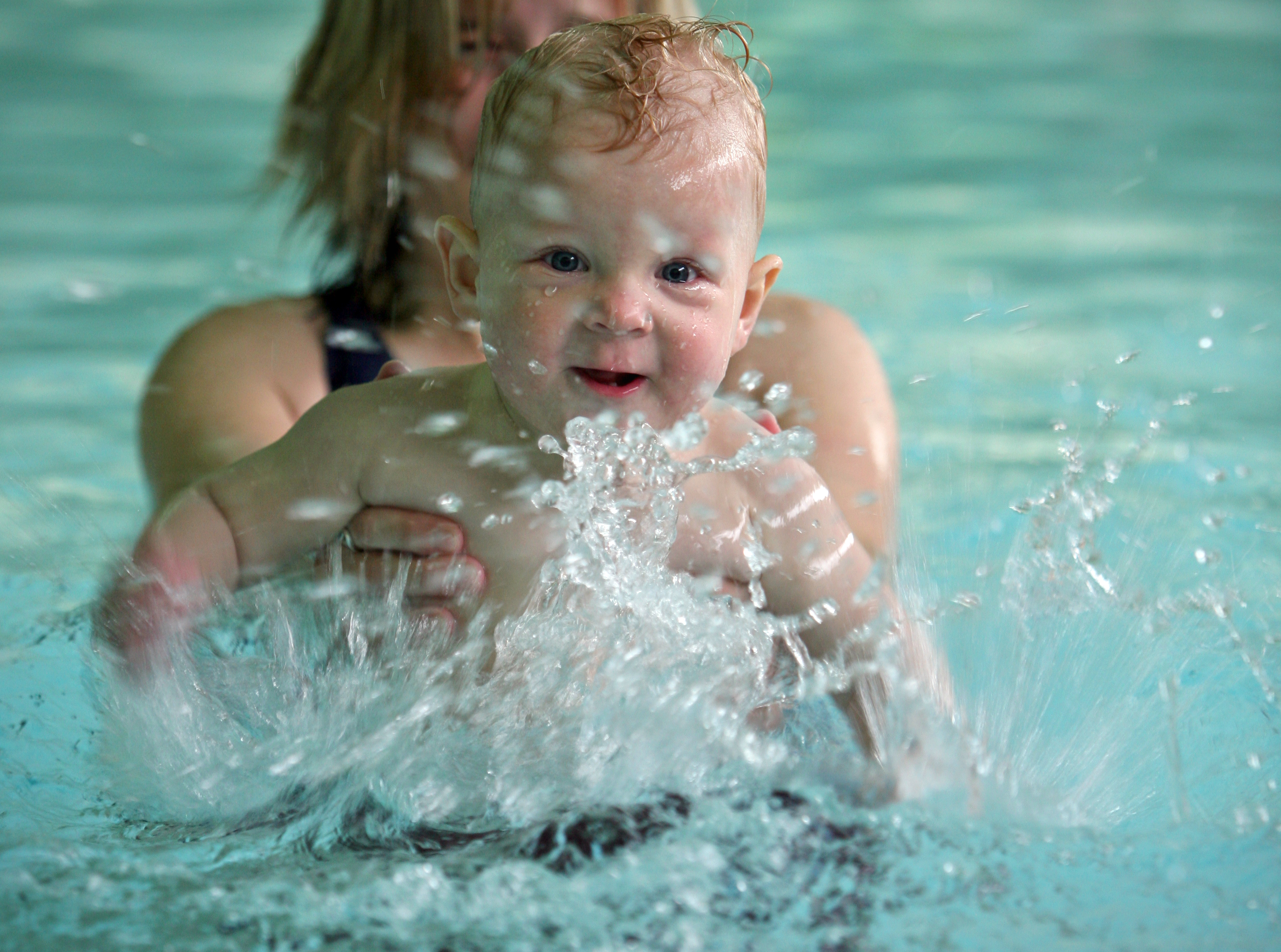 young baby splashing in water