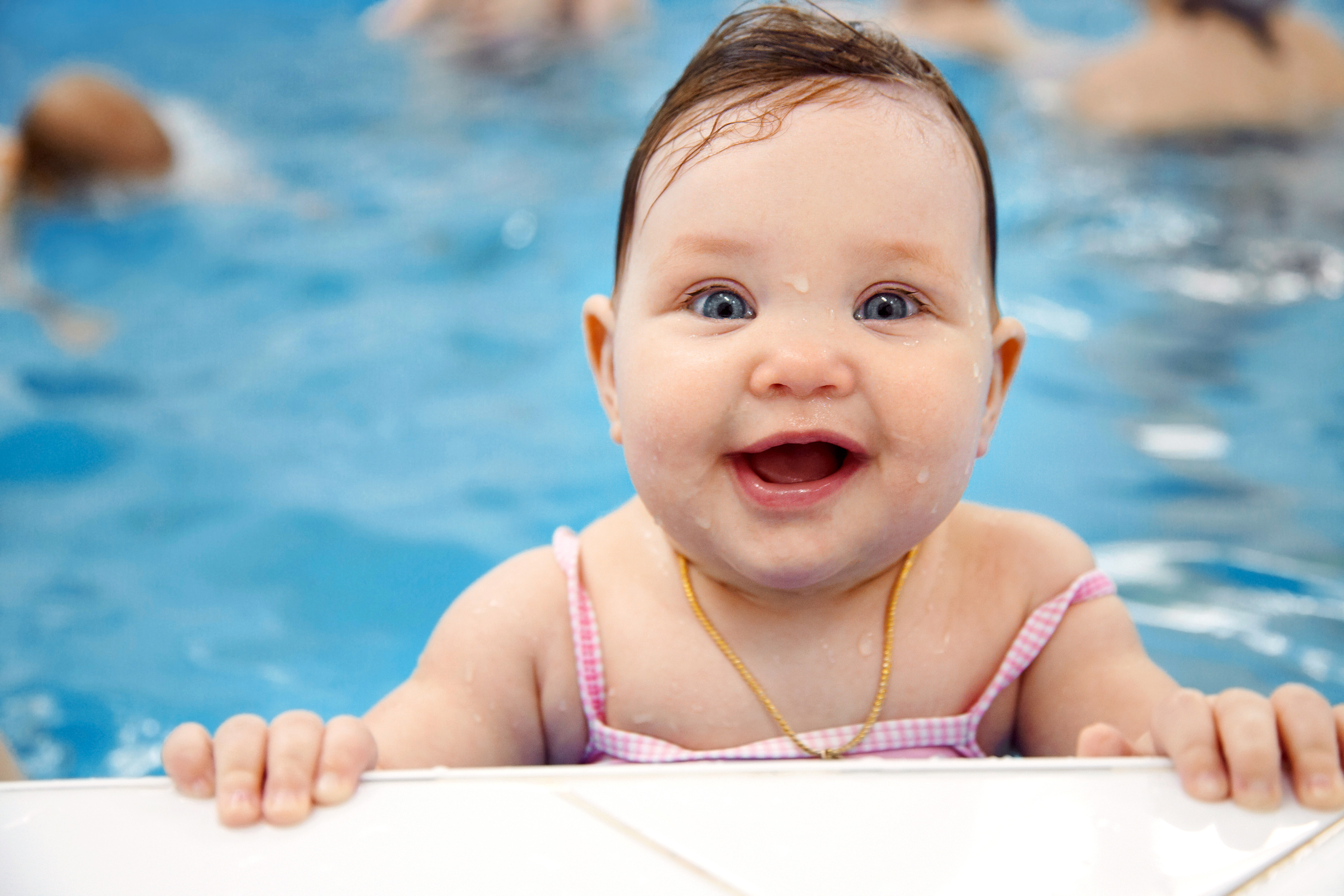 Toddler in swimming pool looking into camera