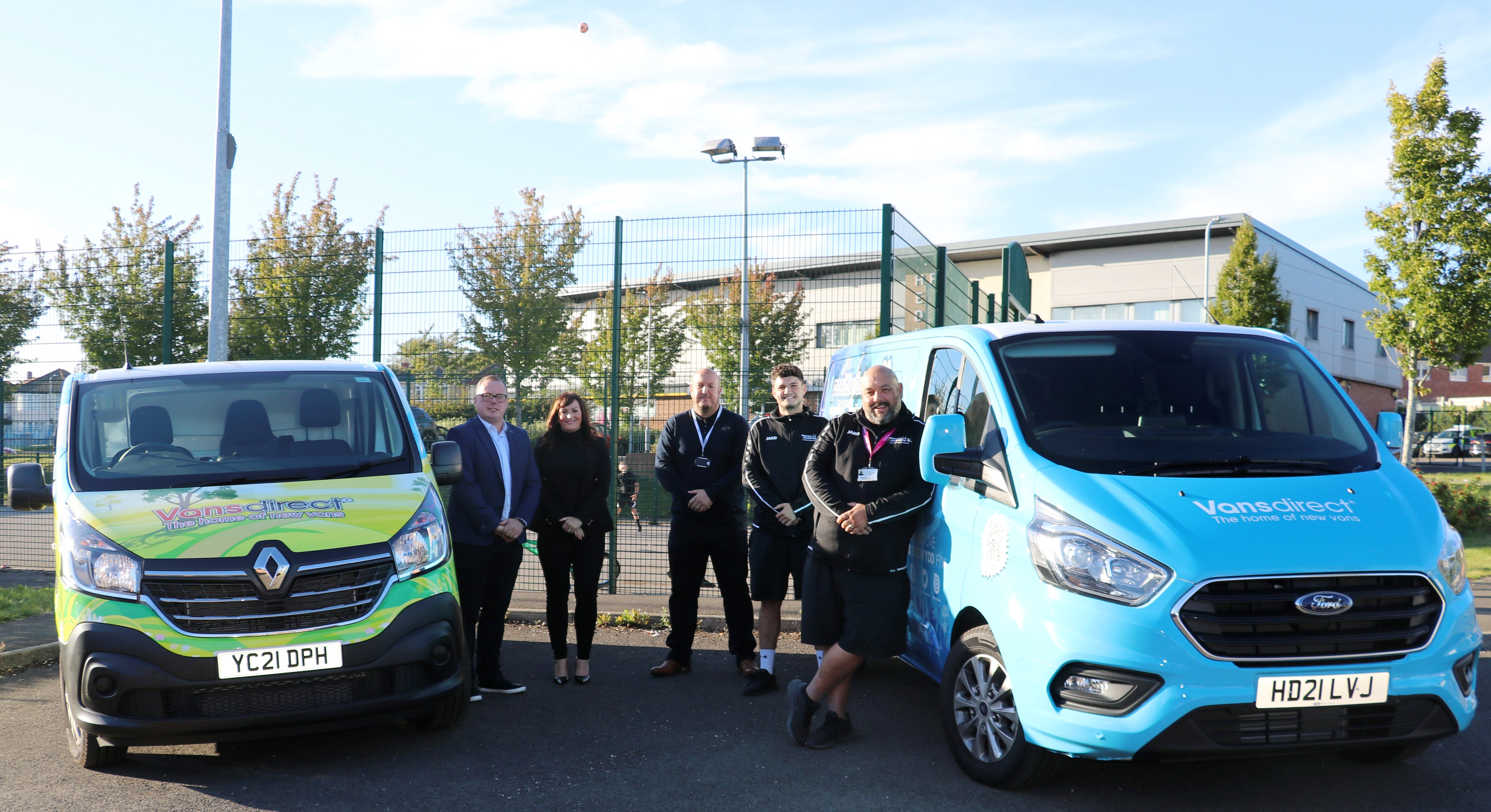 Staff members from Vansdirect and Newport Live standing by branded vans
