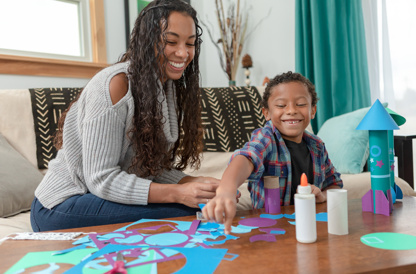 Lady and her young son creating something with paper.PNG