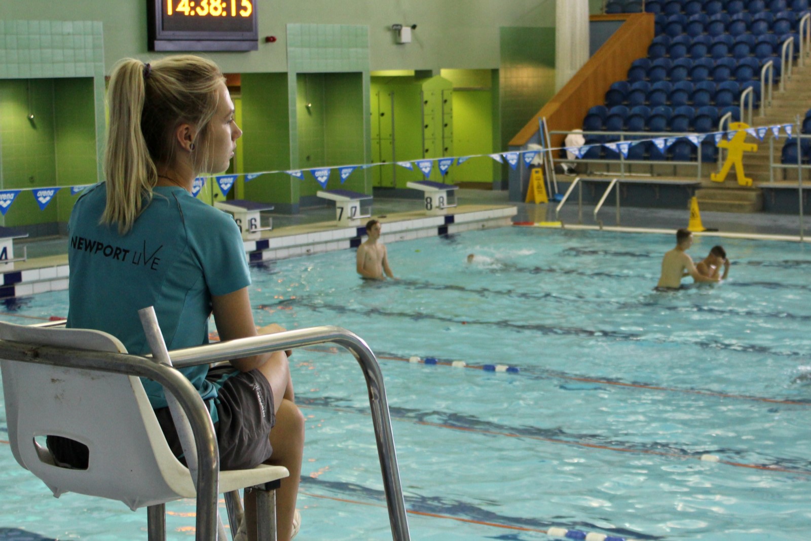 Lifeguard sitting monitoring swimming pool