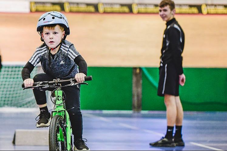 Young boy riding green bike