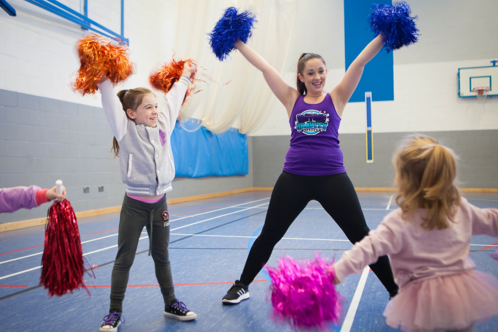 Lady with pompoms teaching a group of children.jpg