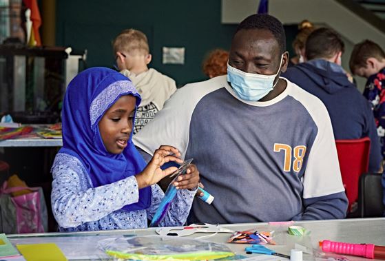 Young girl and her father taking part in arts and crafts activities