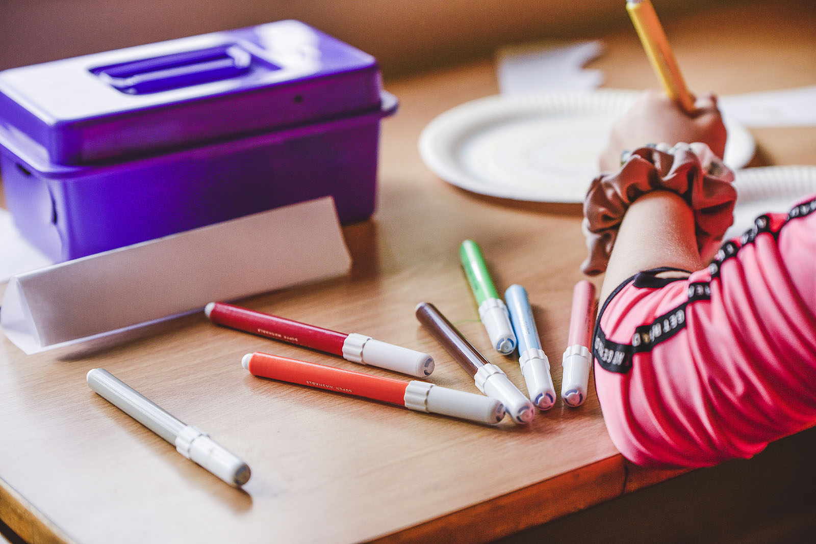 a young child colouring with pencils