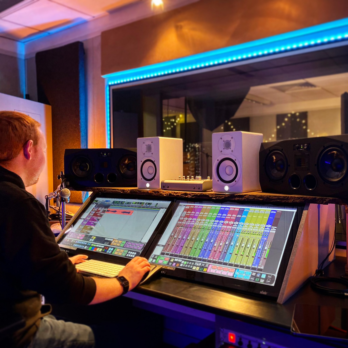 Jordan sitting at mixing desk in recording studio