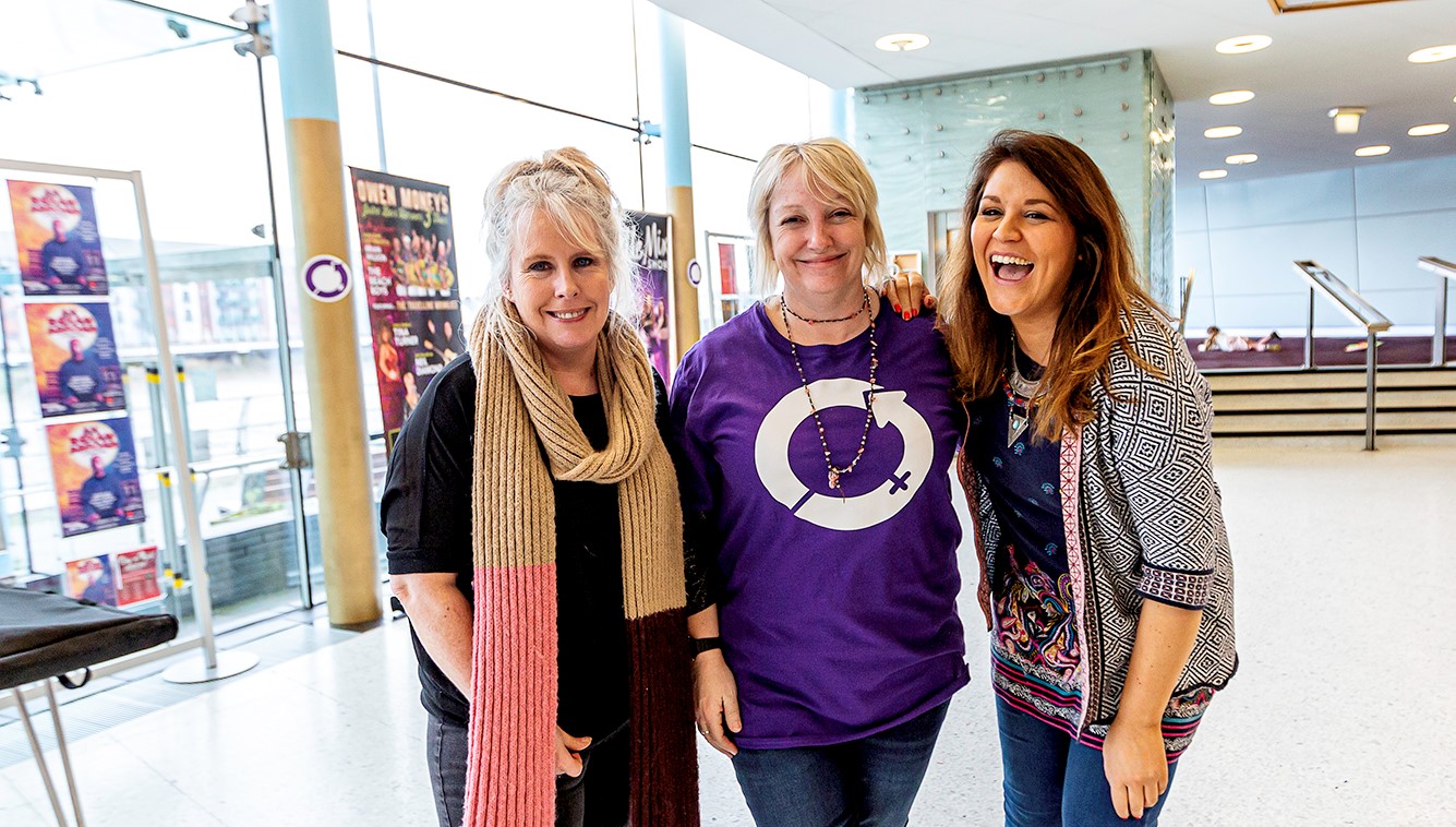 Three ladies smiling, one in IWD tshirt