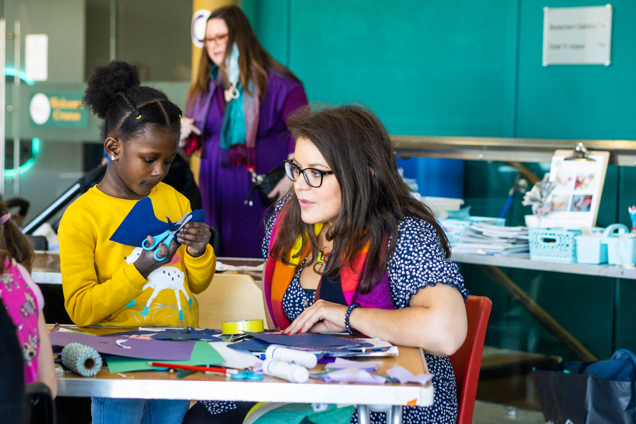 Child in yellow taking part in arts and crafts activities