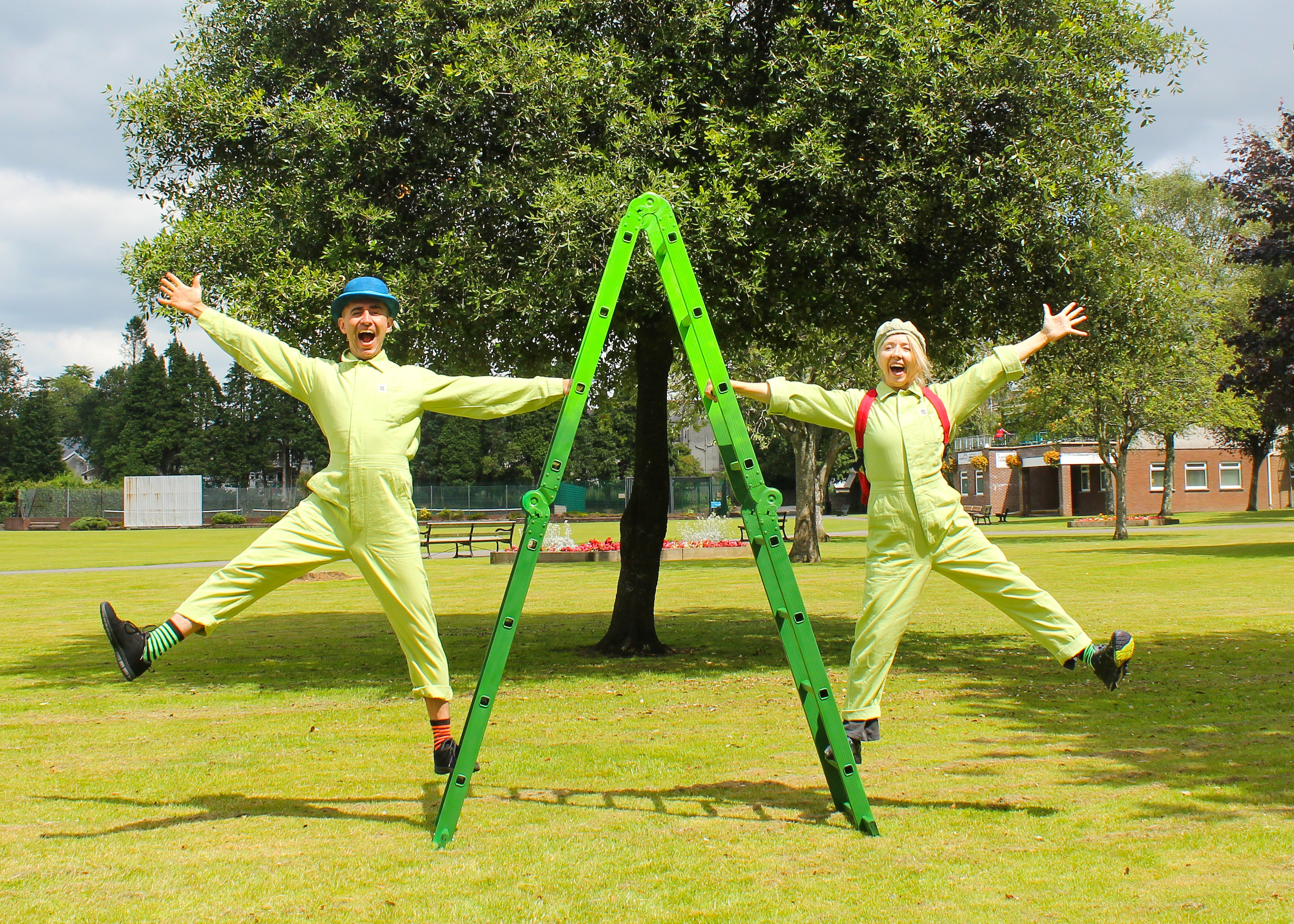 two happy performers next to a green ladder