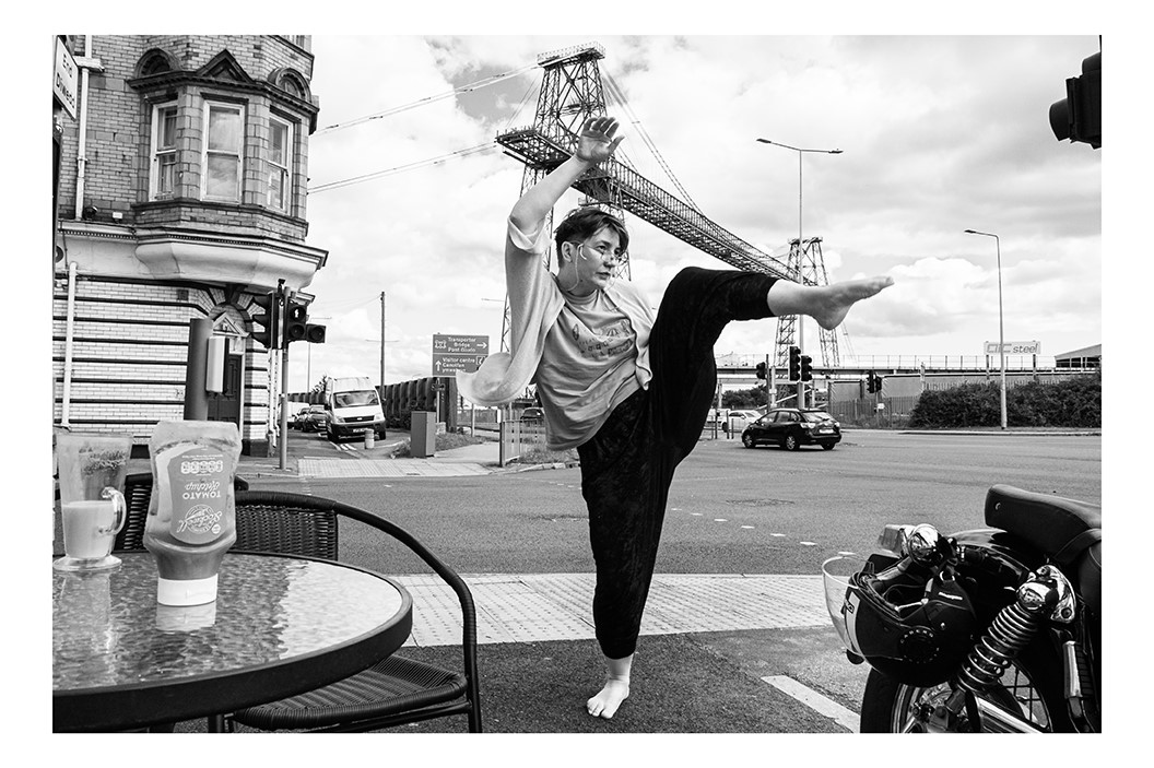 Black and white image of a lady doing yoga in front of the Transporter Bridge