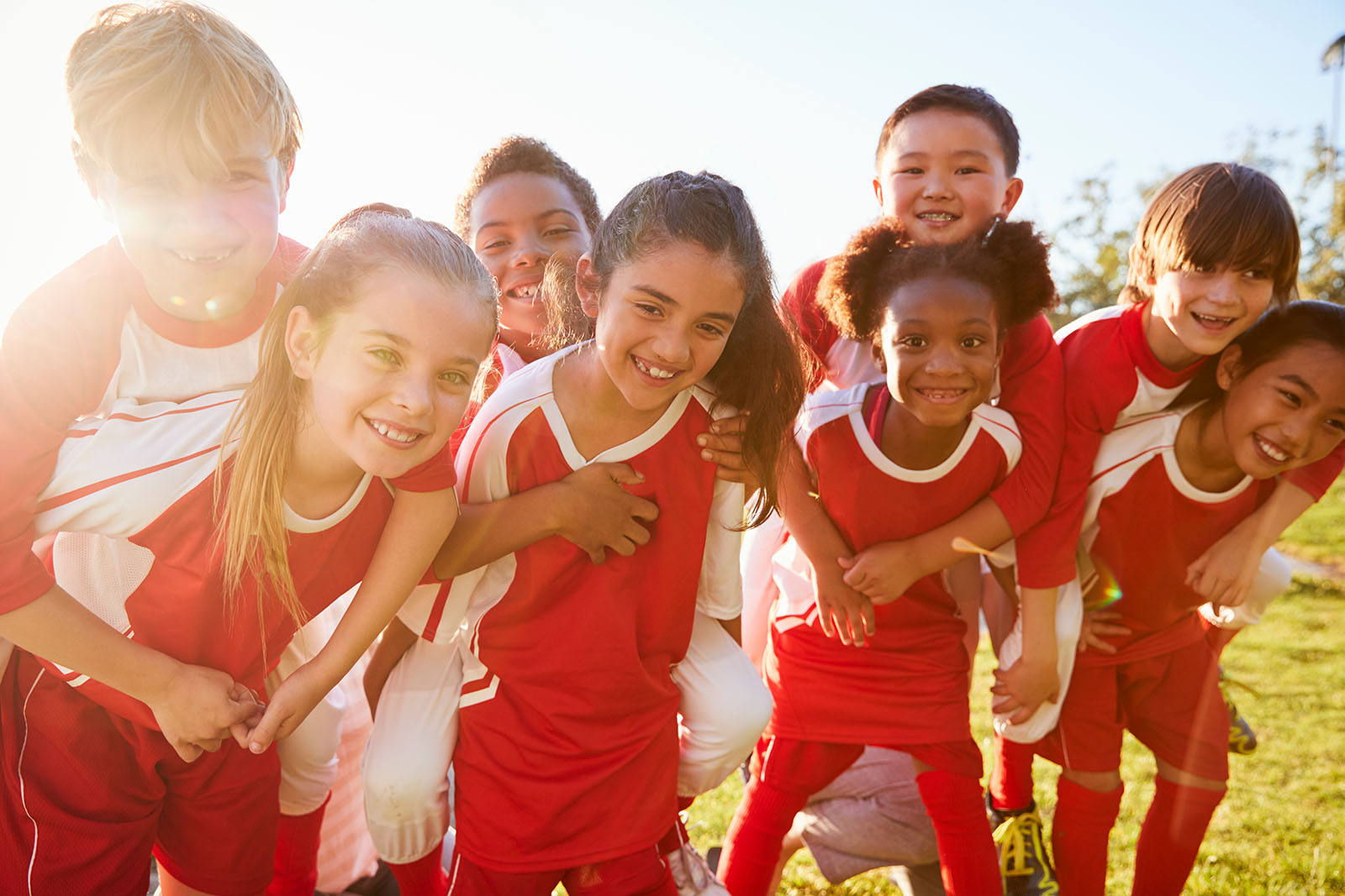 young football team huddling wearing red football kits