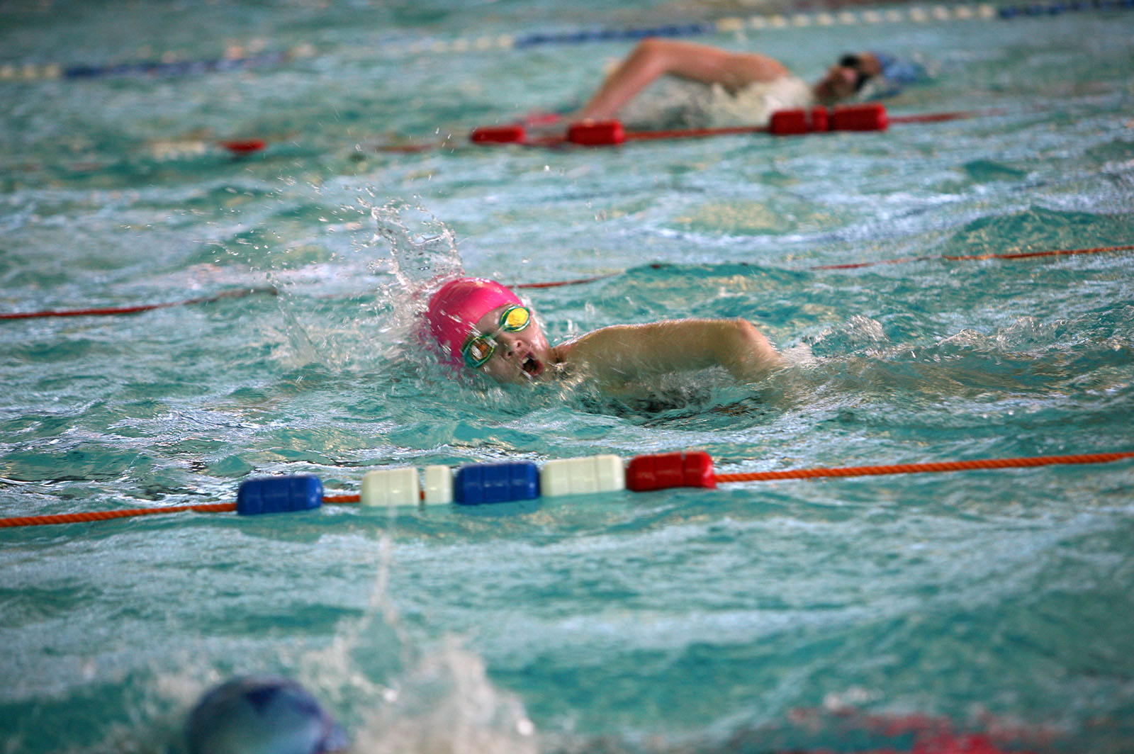 young boy swimming lengths in a swimming pool