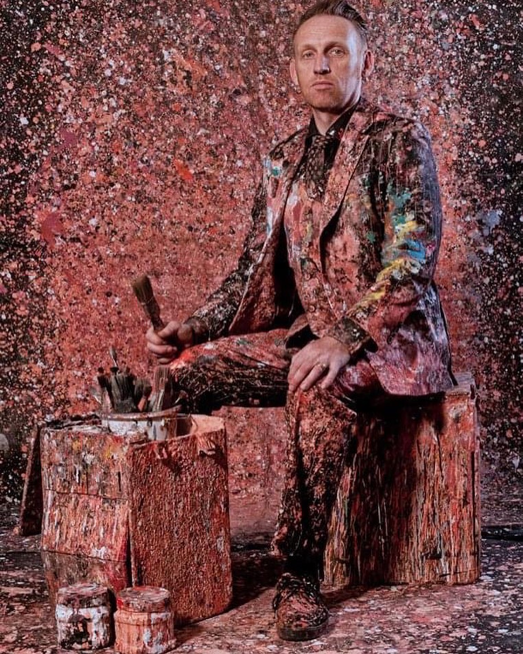 Man sitting covered in paint