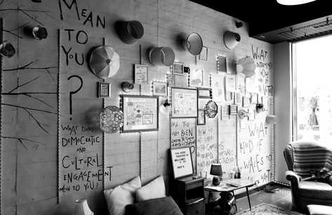 Black and white image of room covered in signs and posters