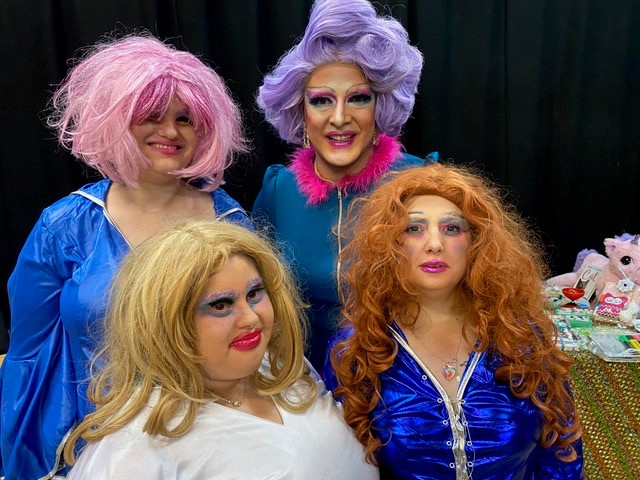 Group of 4 people dressed in drag costumes and wigs