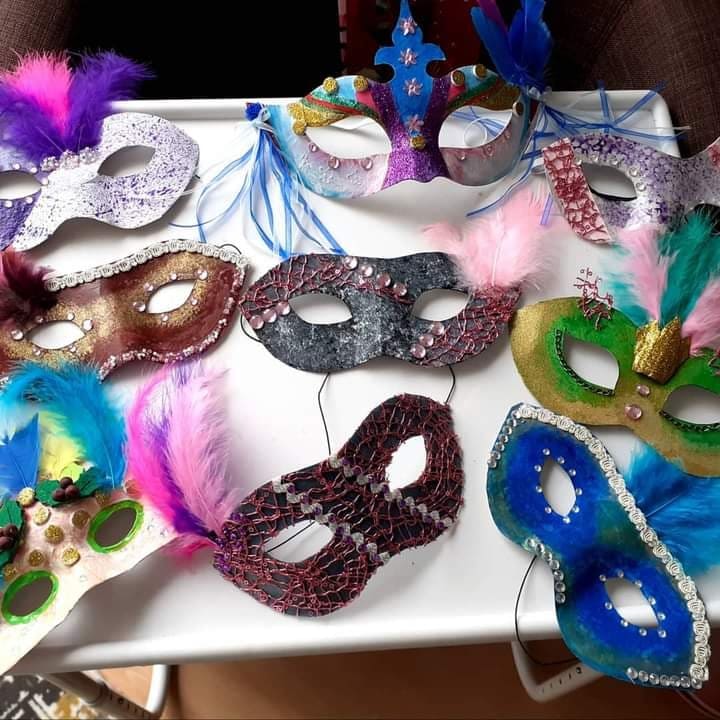 Close up image of glittered and feathered masks on a table