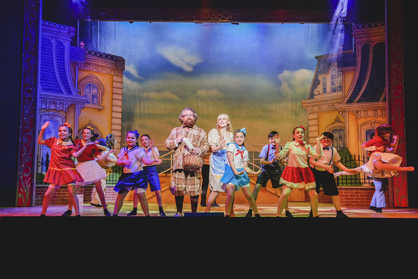 adults and children performing on a stage in cinderella panto