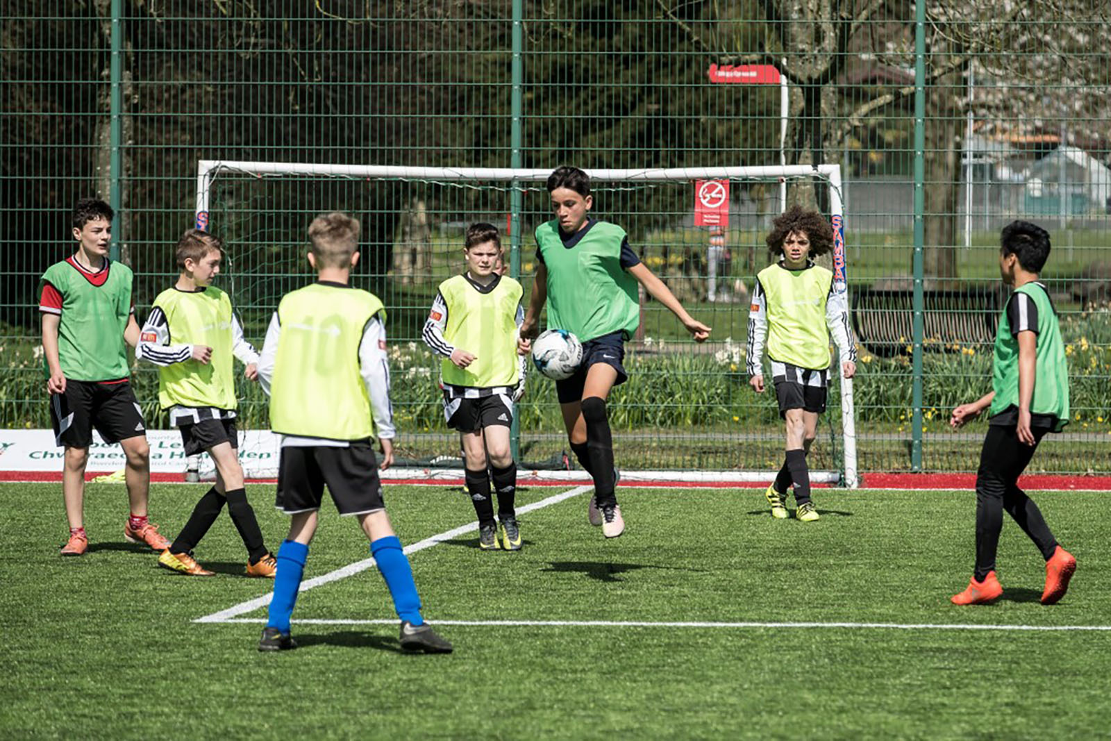 group of young boys playing football on an outside pitch