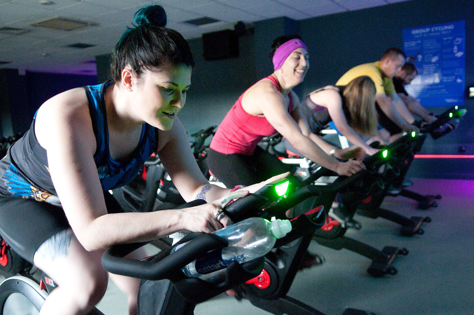 group of women riding on indoor cycling equipment
