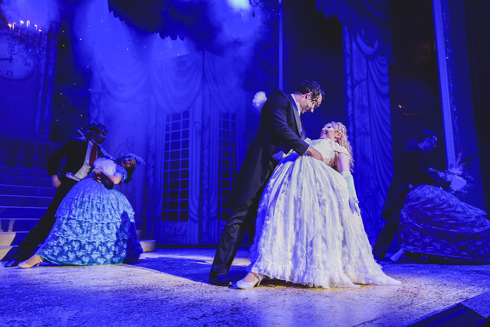 blue lit stage with prince charming and cinderella in panto performance
