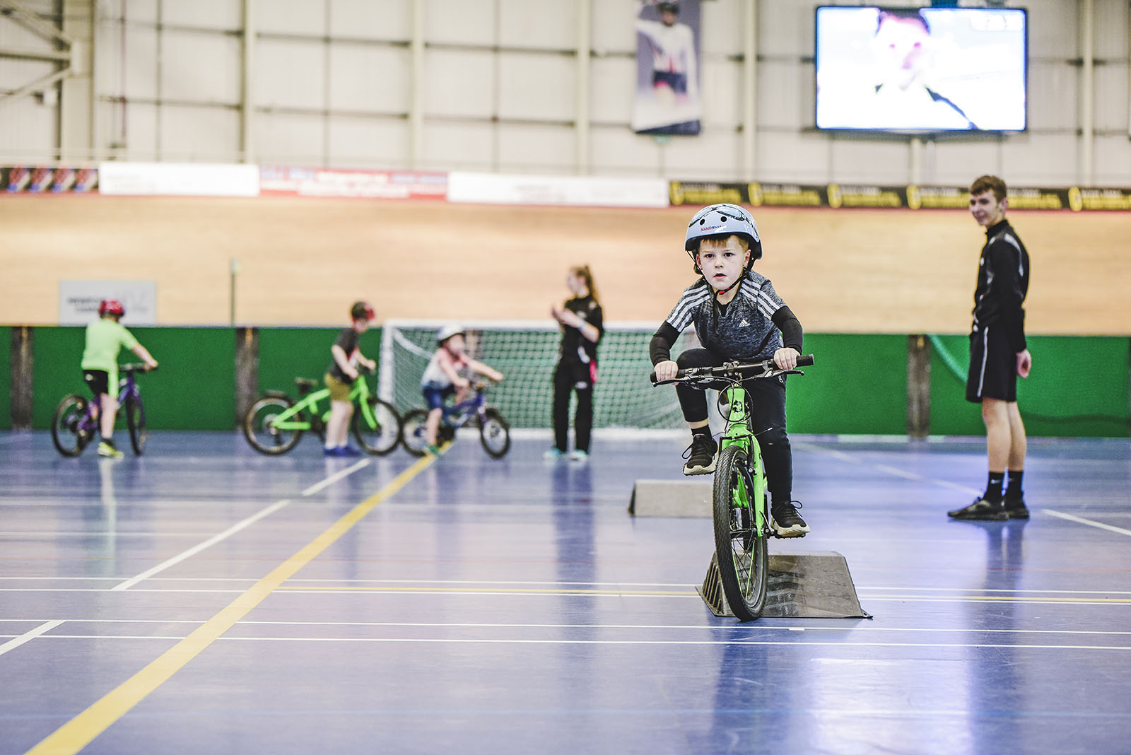 Young boy riding green bike