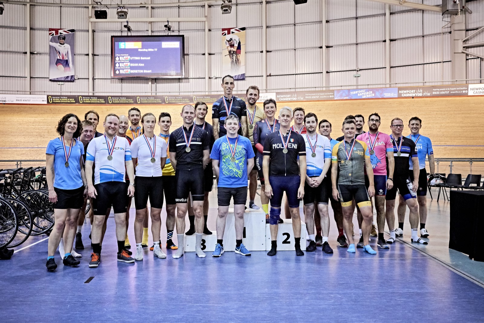 Group of people in cycling kit wearing medals