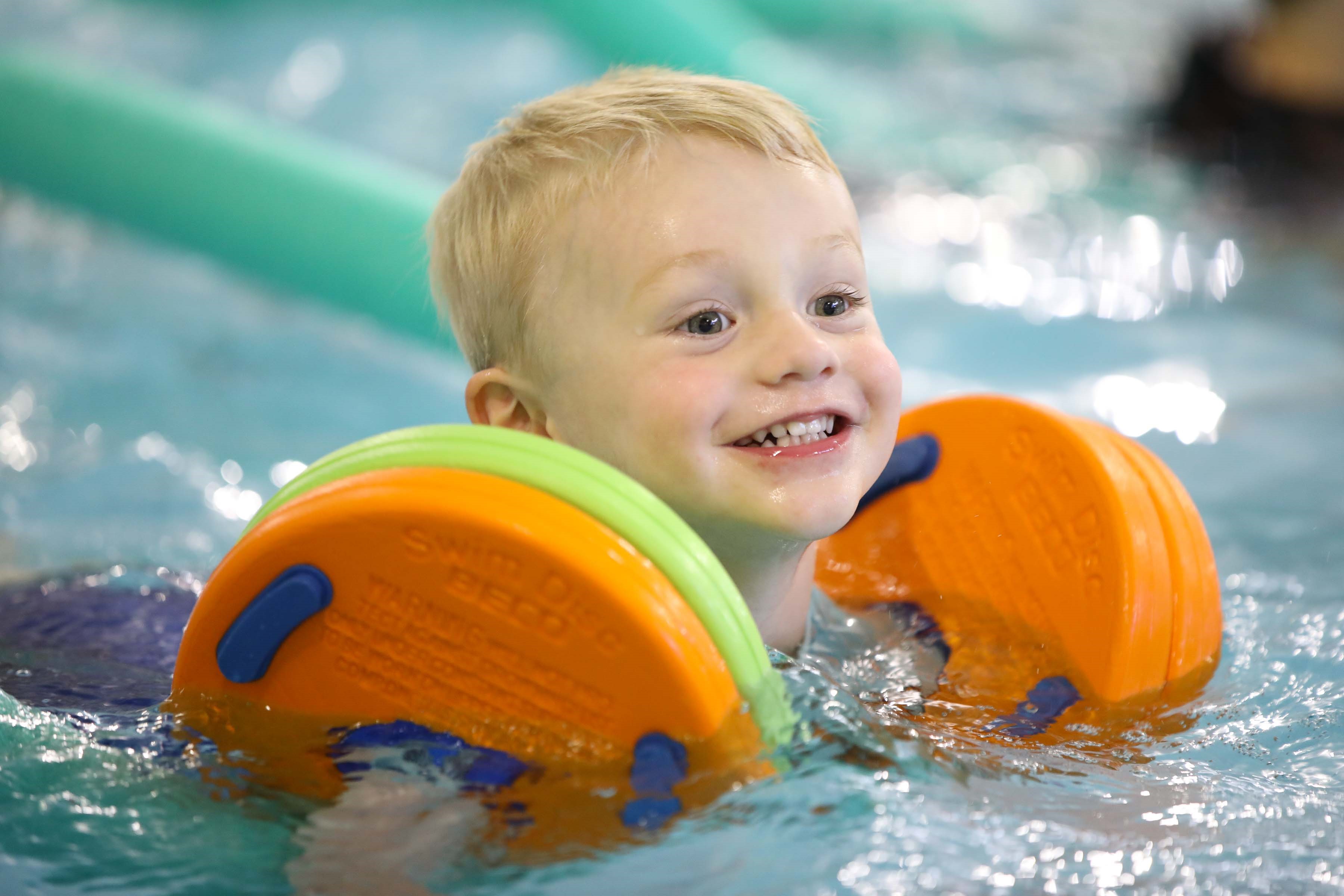 Little boy with orange arm floats in a pool Little boy with orange arm floats in a pool