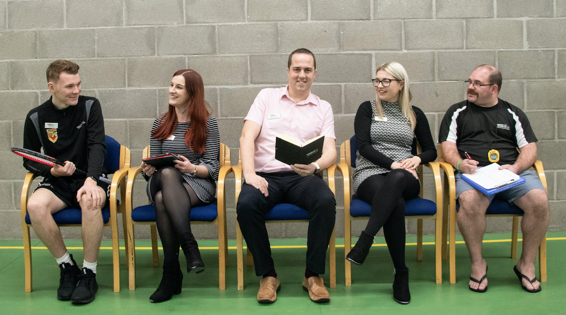 5 staff members sitting in a row