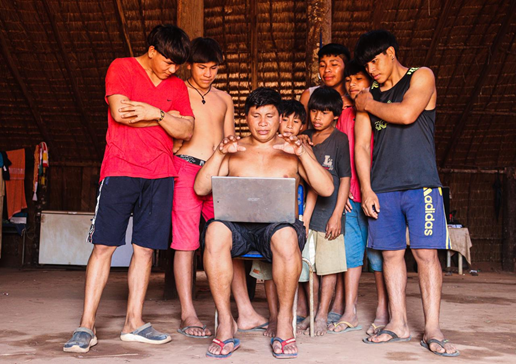 Group of Brazilian children sitting around a laptop