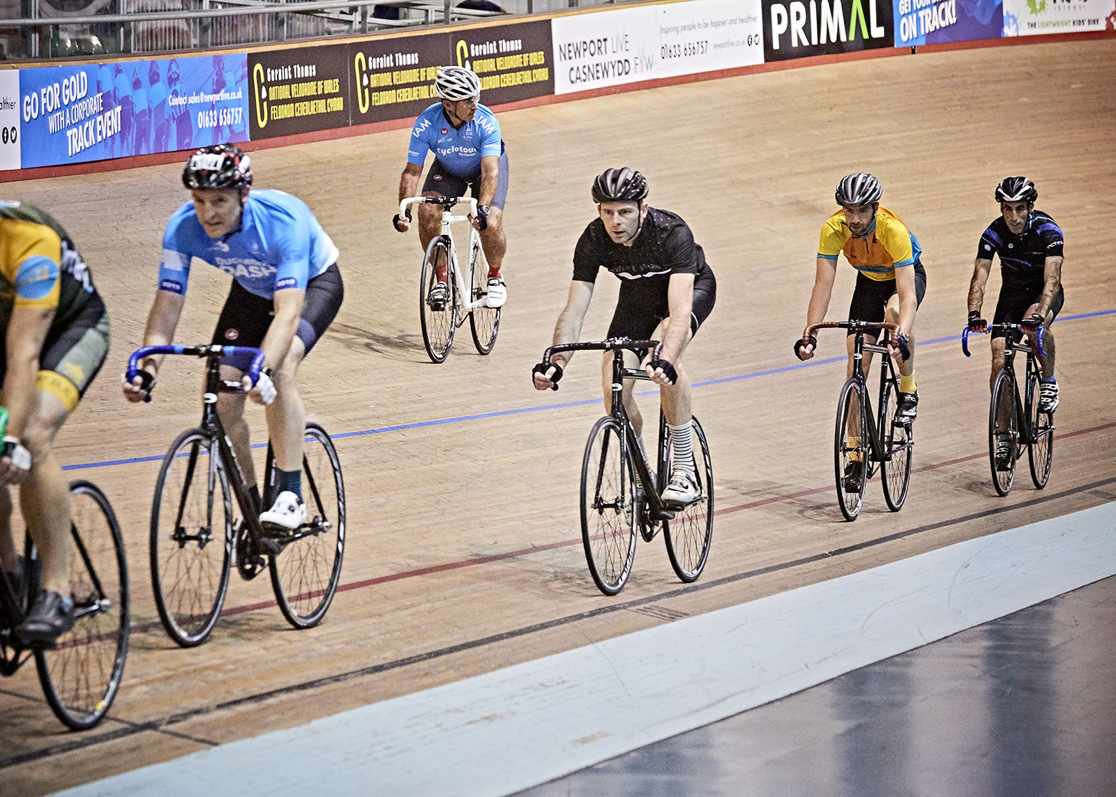 mix of people track cycling on an indoor track