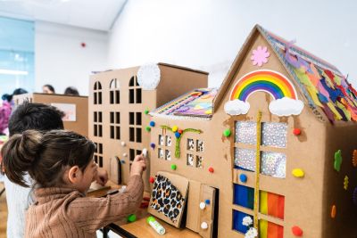 Children decorating cardboard houses 